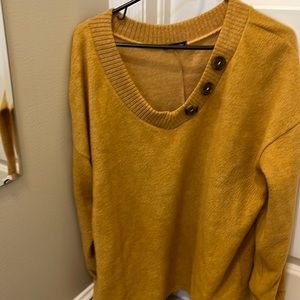 Trendy boutique top with button accent around neckline.